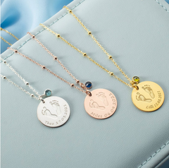 three nicu mom necklaces with preemie baby footprints engraved with birthdates, one sliver one bronze one gold