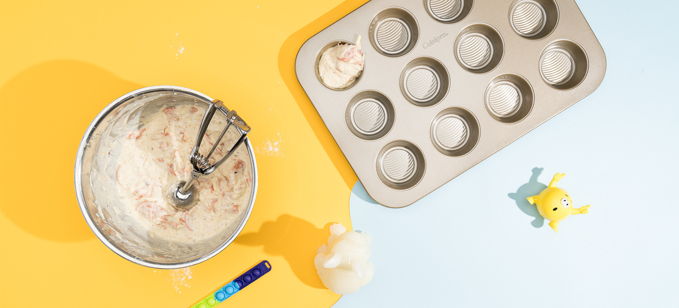 Cuisipro pizza muffin recipe, batter being scooped into Cuisipro Muffin tin, using Cuisipro disher scoop.
