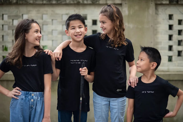 Hayden and his three siblings wear custom black braille t-shirts