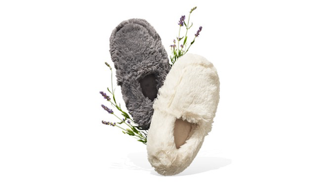 one grey and one ivory fuzzy slipper with sprigs of lavender behind them