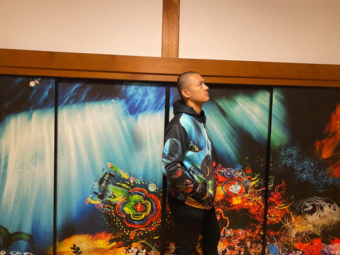 EKOIN Chief priest Sesshu Kondo standing in front of the Unissograff 'Shingon Shōmyō Symphony' design sliding door