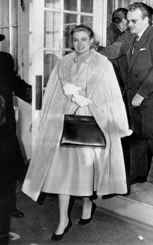 Grace Kelly holding a Hermes Kelly to cover her belly