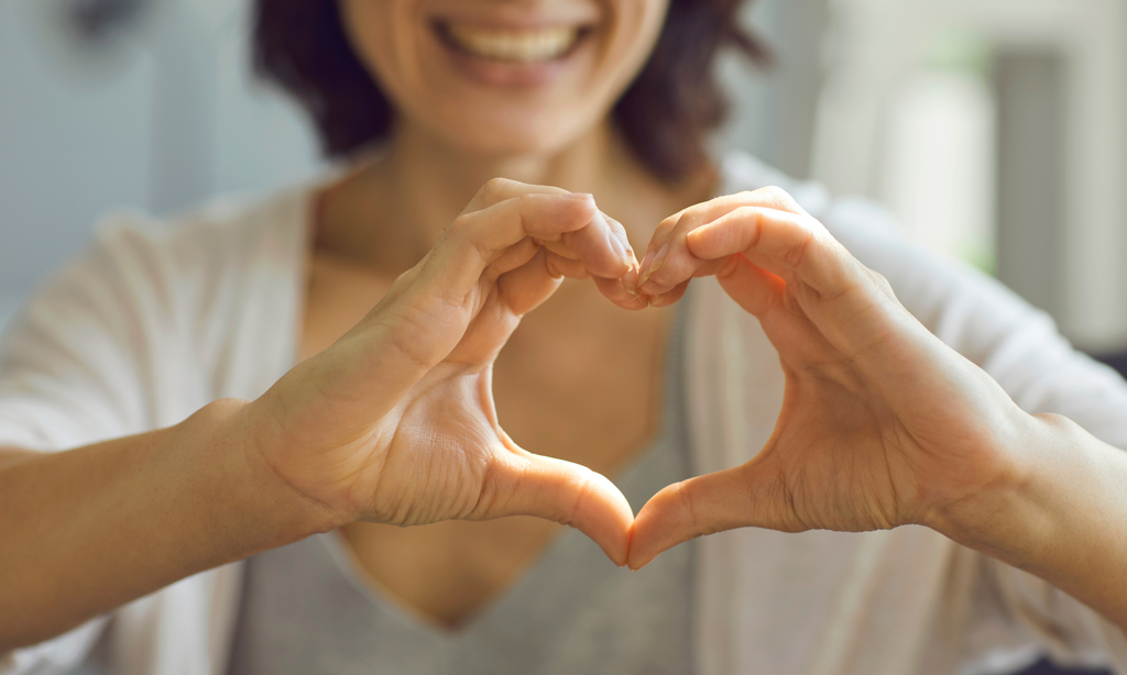 A Woman making a heart shape with her hands as in showing gratitude and loves