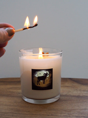 hand with match lighting aries zodiac intention candle