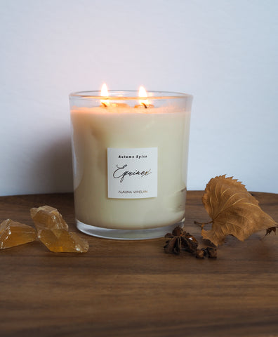 autumn spice luxury soy candle for fall equinox on wooden tray with crystals and fall leaves