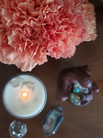birds eye view of luxury candle with fresh pink carnations and crystals