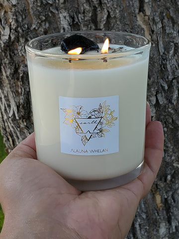 earth sign candle in palm of hand with tree bark background