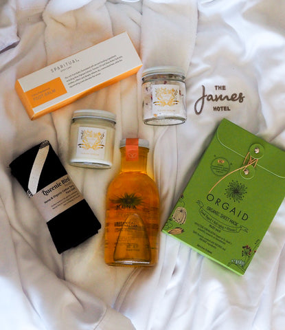 a variety of self-care spa products on plush white bath robe