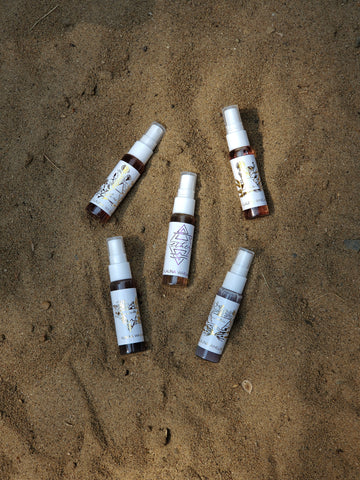 five small travel ritual mists with sandy backdrop