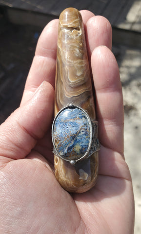 brown and blue crystal talisman ritual wand in palm of hand