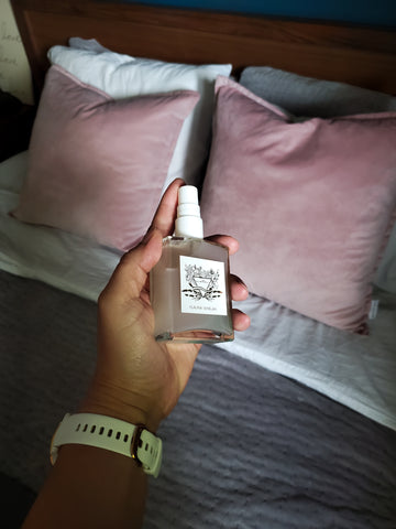 hand holding crystal infused lavender luxury linen spray for bed linens