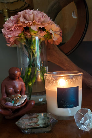 luxury new moon soy candle with crystals goddess statue and fresh cut flowers