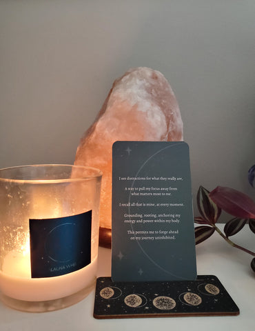 altar with new moon lunar intention candle, oracle card, and crystals