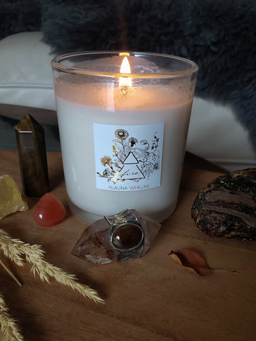 lit luxury soy fire element candle on wooden altar with assorted crystals