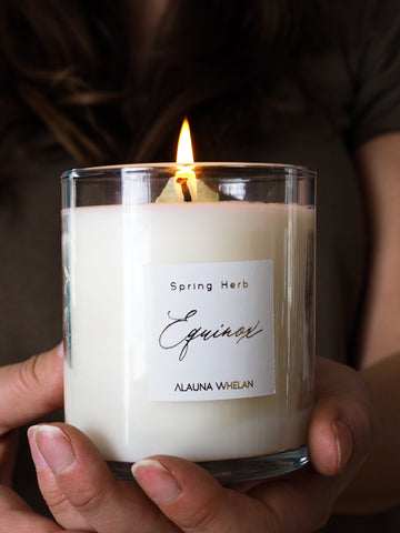 hands holding lit soy candle