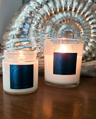 two luxury soy lunar candles on wooden surface with mirrored shell in the background