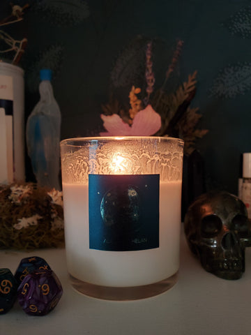 waning moon lunar candle with blue and gold label surrounded with crystals and dried flowers