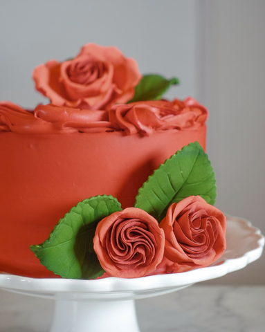 red frosted cake with red sugar flower