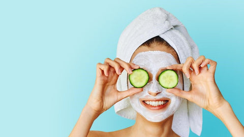 Photo of woman wearing a face mask and cucumbers on eyes
