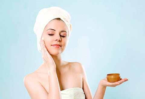 Photo of woman applying moisturizer to her facial skin