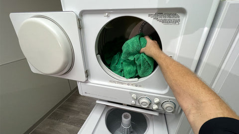 putting microfiber towels into the dryer 