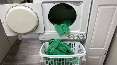 microfiber towels from the dryer into a basket  