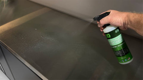 spraying counter with cleaner 