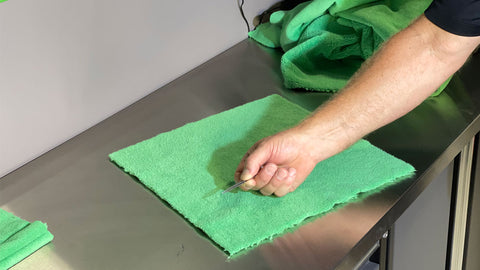 pulling string from microfiber towel with tweezers 