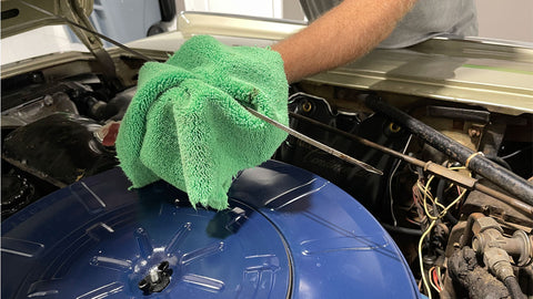 checking car oil with a microfiber towel 