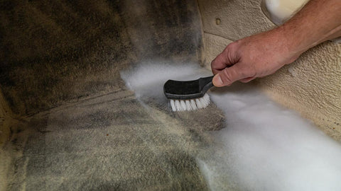 agitating car floor with cleaner and a brush