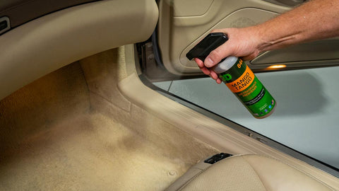spraying air freshener on car upholstery  
