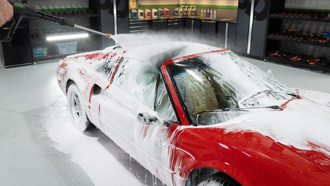 spraying foam off car with water 