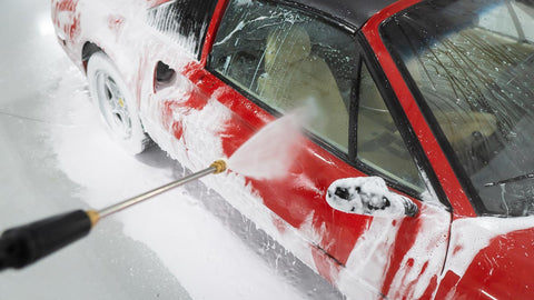 spraying foam off car with water 
