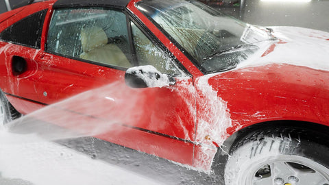 spraying foam off car with water 