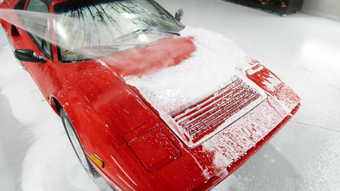 spraying foam off car with water 