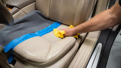 wiping car seat clean with a microfiber towel 