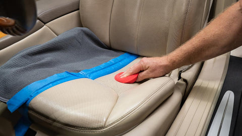 applying leather conditioner to car seat 