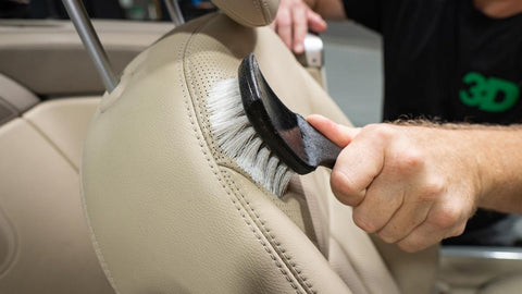 scrubbing leather car seat with a brush 