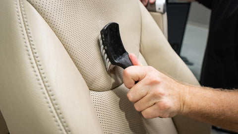 scrubbing leather car seat with scrub brush 