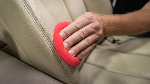 rubbing leather conditioner into car seat 