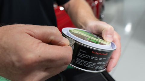 using a quarter to open a can of car wax