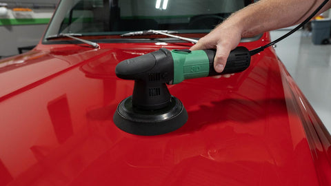 waxing a car with a rotary polisher 