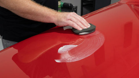 smoothing wax onto the surface of a car 