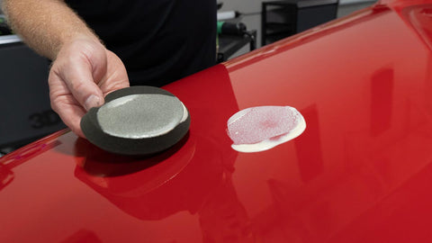 dabbing wax onto the surface of a car 