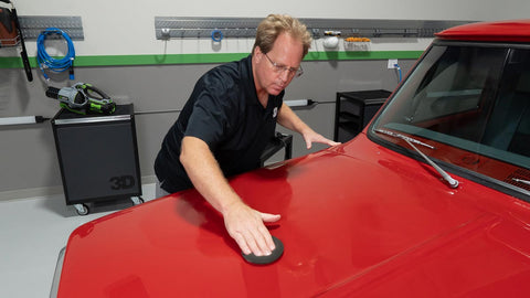 man waxing surface of a car 