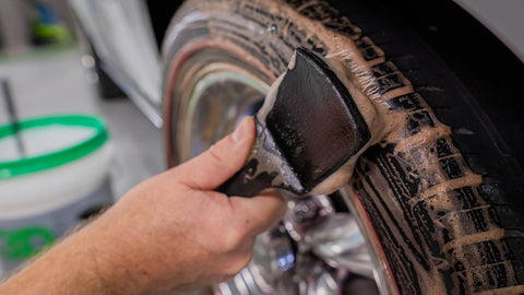 scrubbing car tire with degreaser 