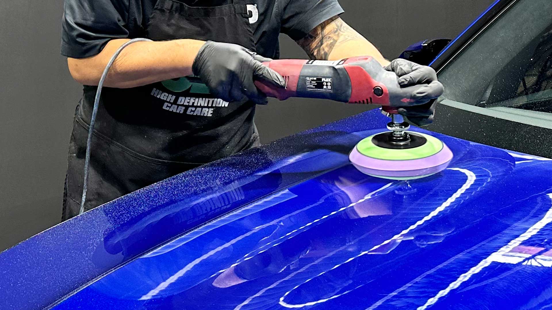 buffing hood of blue car