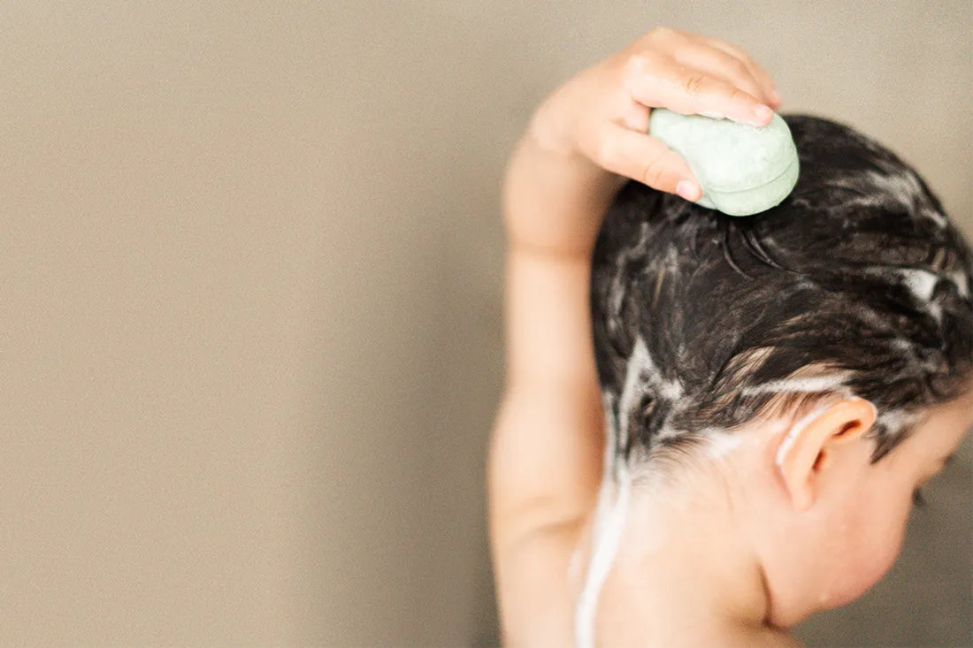 plain b kids shampoo in use - a child washes its own hair with the solid children's shampoo from plain b | WingGuard.de