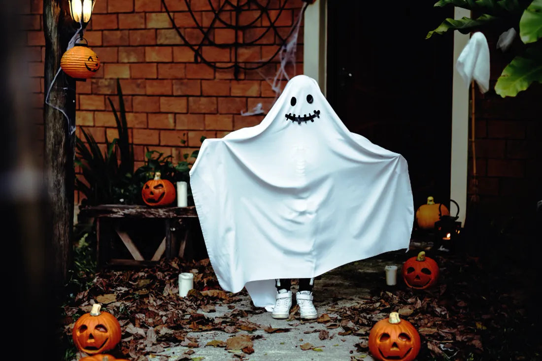 Child in ghost costume made from bed sheets