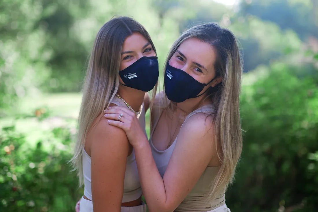Female friends wearing masks and looking at the camera in a friendly manner